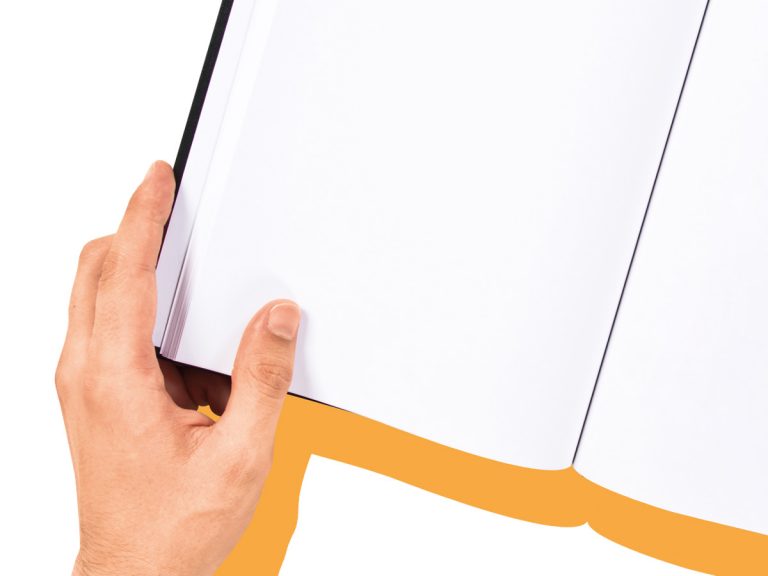 Eine Hand hält ein aufgeschlagenes Buch mit leeren Seiten in den Händen.